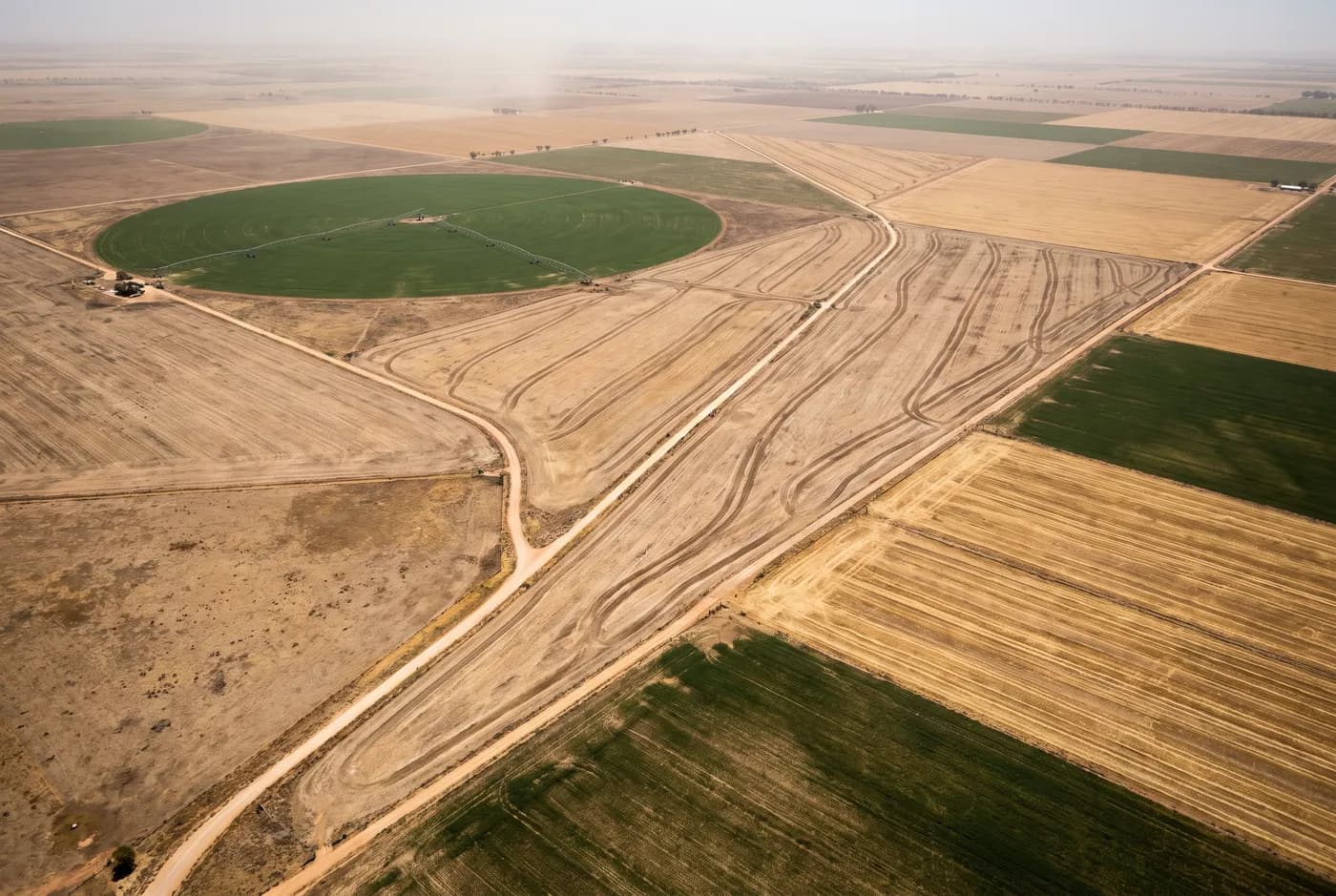 Broadacre cropping paddocks and a centre pivot photographed from altitude